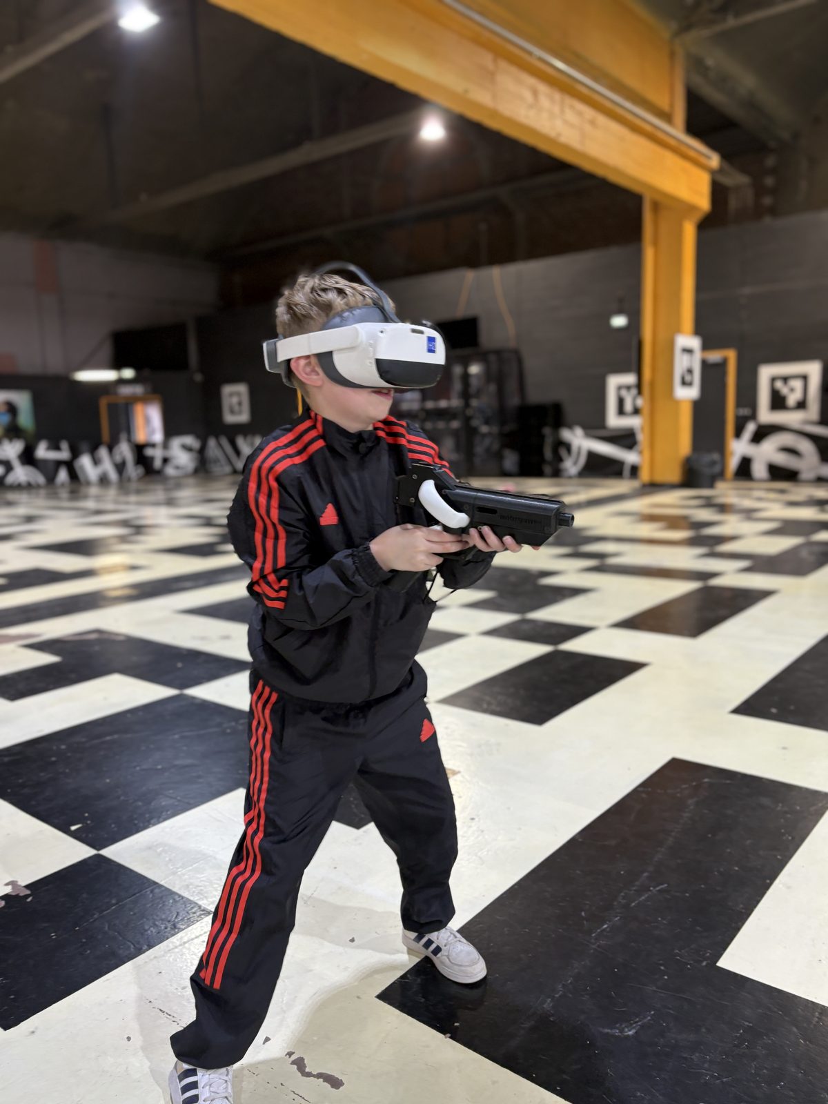 Un enfant équipé d'un casque VR et d'un contrôleur pendant une session chez Team Square